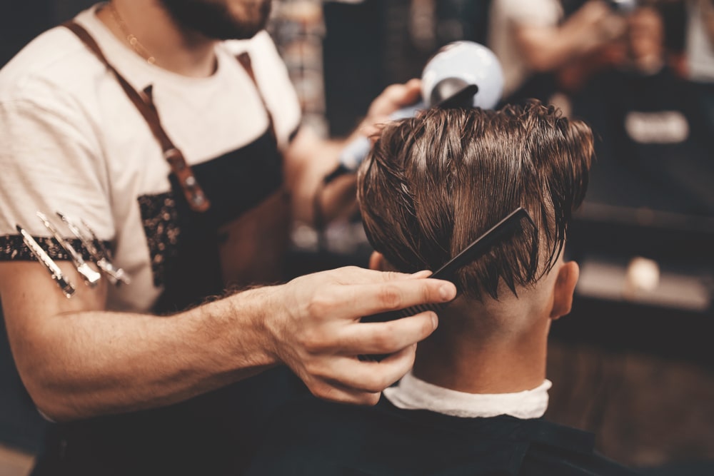 barber combing through man's hair