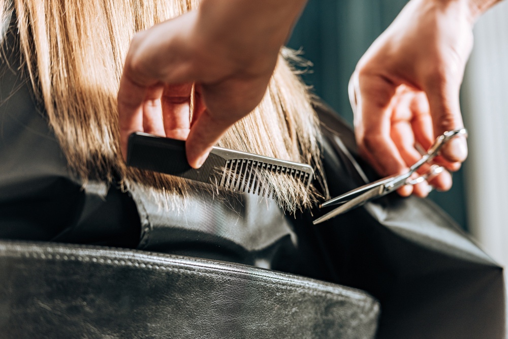 cosmetologist cutting hair