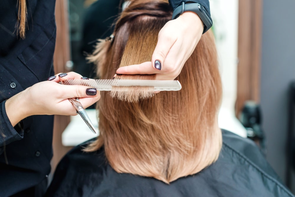 hair stylist cutting a woman's hair