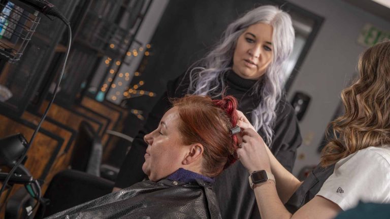 Instructor styling a woman's hair at Austin Kade Academy.