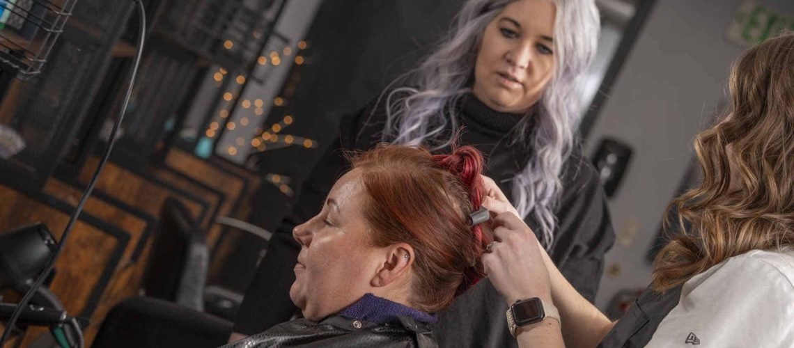 Instructor styling a woman's hair at Austin Kade Academy.