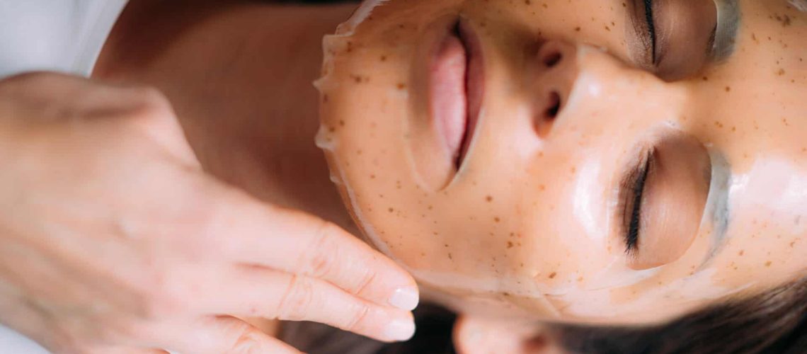 Woman receiving facial treatment in a cosmetology salon.