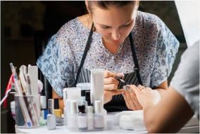Nail technician applying nail polish during training at Austin Kade Academy