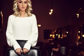 Elegant woman in a stylish white sweater at Austin Kade Academy, modern interior