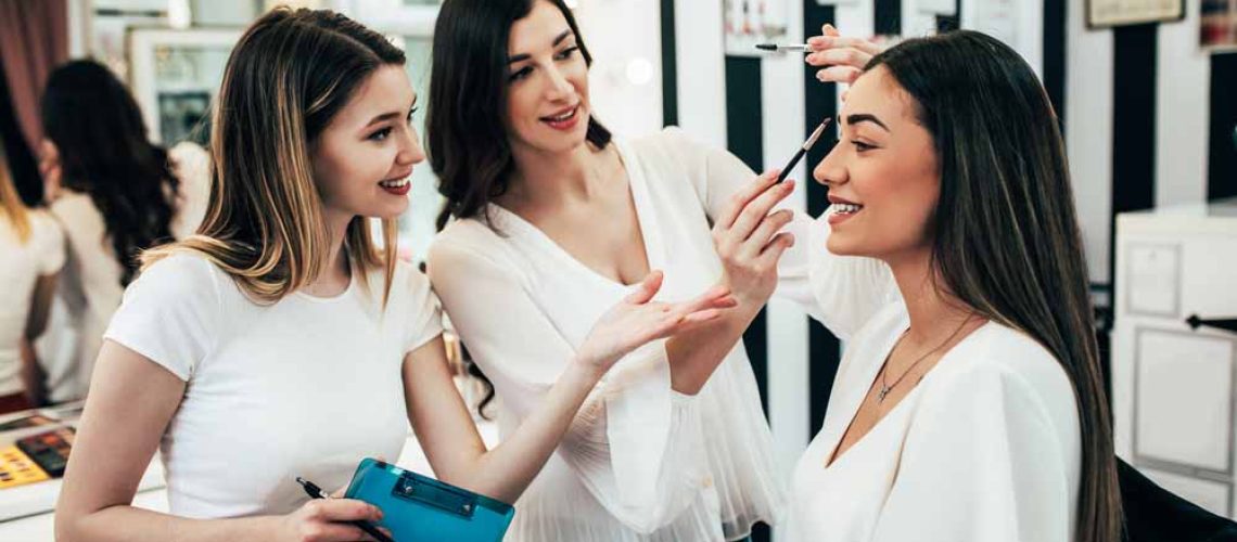 Professional makeup artist teaching student in makeup school.